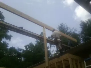 Carpenter setting a ridge beam over a new addition frame — Ice Dam Removal by Roofing Brothers in Egg Harbor City