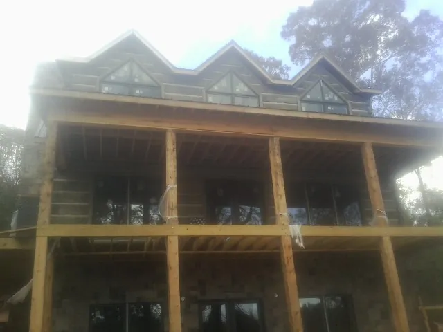 Dormers and porch framing on a large log home under construction — Roof Coating work by our crew in Egg Harbor City