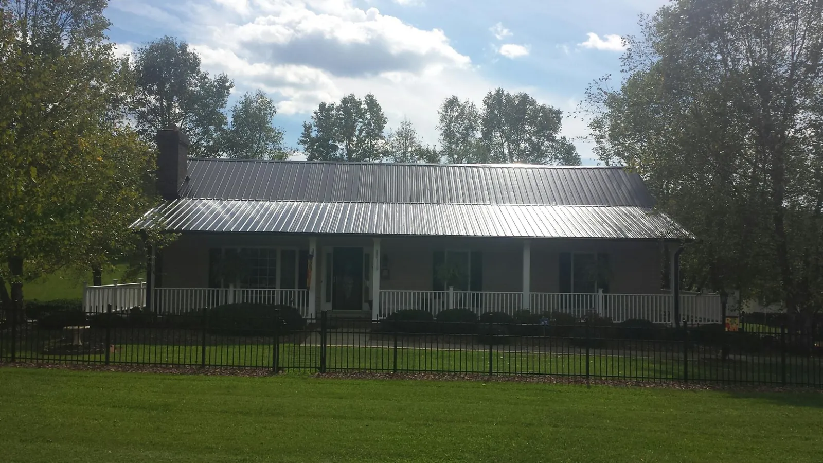 Gray metal roof on a brick ranch with a full width front porch — Gutter Guard Installation work by our crew in Egg Harbor City